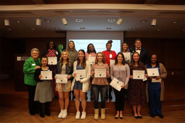 A group of women holding J. Edwin Givens Scholarship awards