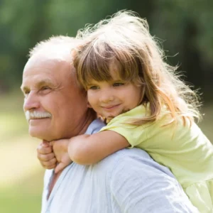 Senior giving a piggyback ride to a young girl