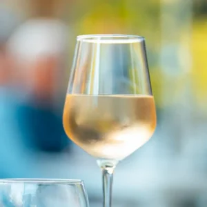 A glass of cool white wine sitting outdoors at Covenant Woods